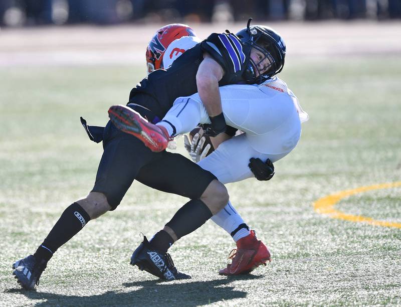 Downers Grove North's Owen Thulin makes an open field tackle on Normal Community's Mar’Quan Gary (3) during an IHSA Class 7A semifinal game on Nov. 18, 2023 at Downers Grove North High School in Downers Grove .