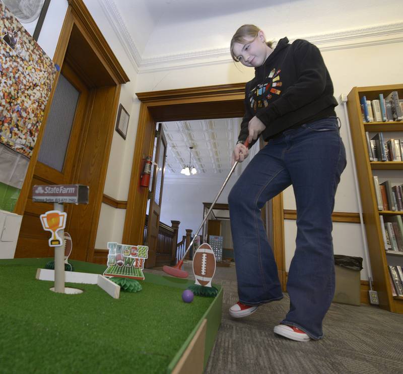 Belle Dean tries to angle her putt Saturday at the 15th hole during the Carnegie Challenge Mini Golf FUN-Raiser at the Streator Public Library.