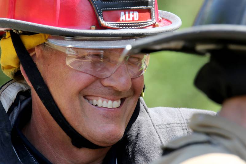 Captain Bill Pelinski smiles as firefighter-paramedics work on training exercises using decommissioned school buses donated by Community Unit School District 300 at the Algonquin-Lake in the Hills Fire Protection District on Thursday, June 17, 2021, in Lake in the Hills.  Three school buses were donated by the school district to the fire department for training exercises.