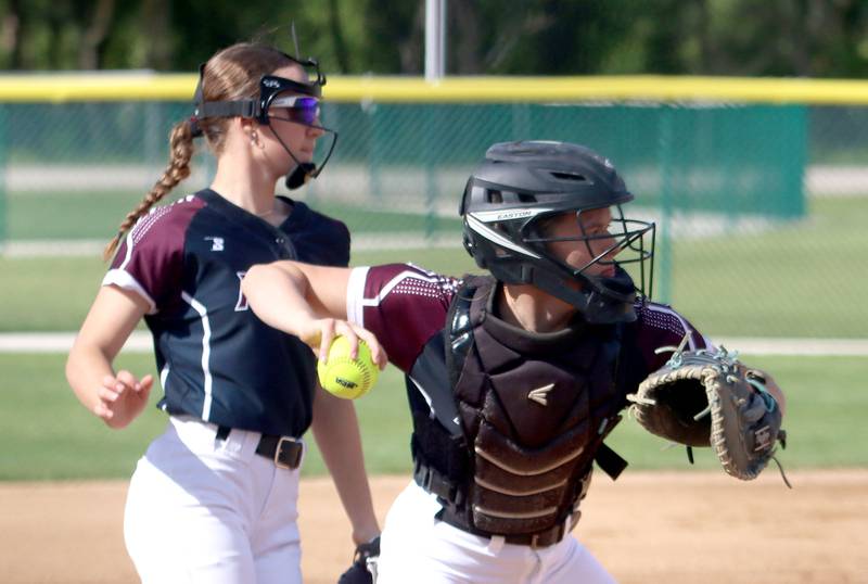 Marengo’s Jozsa Christiansen, back, keeps an eye on the action as Kylee Jensen prepares to toss the ball to first base for an out against Aurora Central Catholic in IHSA Class 2A Regional Title Game action softball at Marengo High School in Marengo on Friday, May 23, 2025.