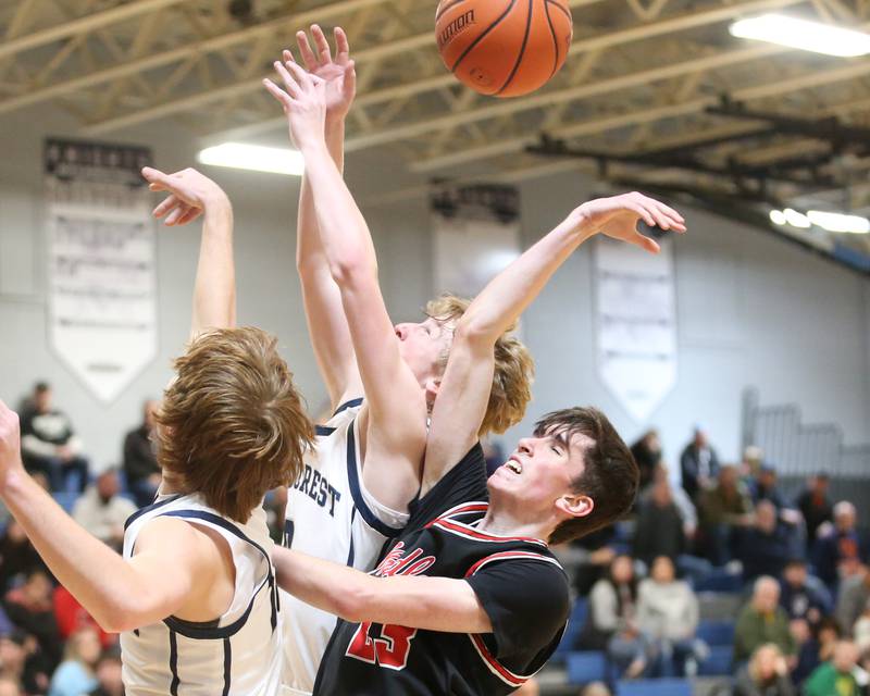 Fieldcrest's Nathan Cook and Jordan Heider try to graba rebound over Woodland's Nick Plesko on Tuesday, Dec. 19, 2023 at Fieldcrest High School.
