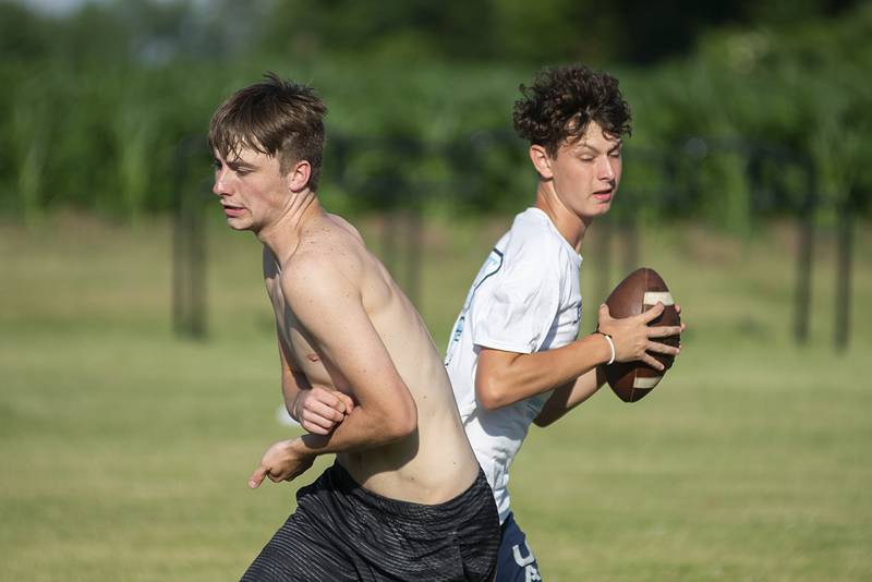 Carter Merdian (right) rolls out for a pass during football drills in Polo Thursday, July 7, 2022.