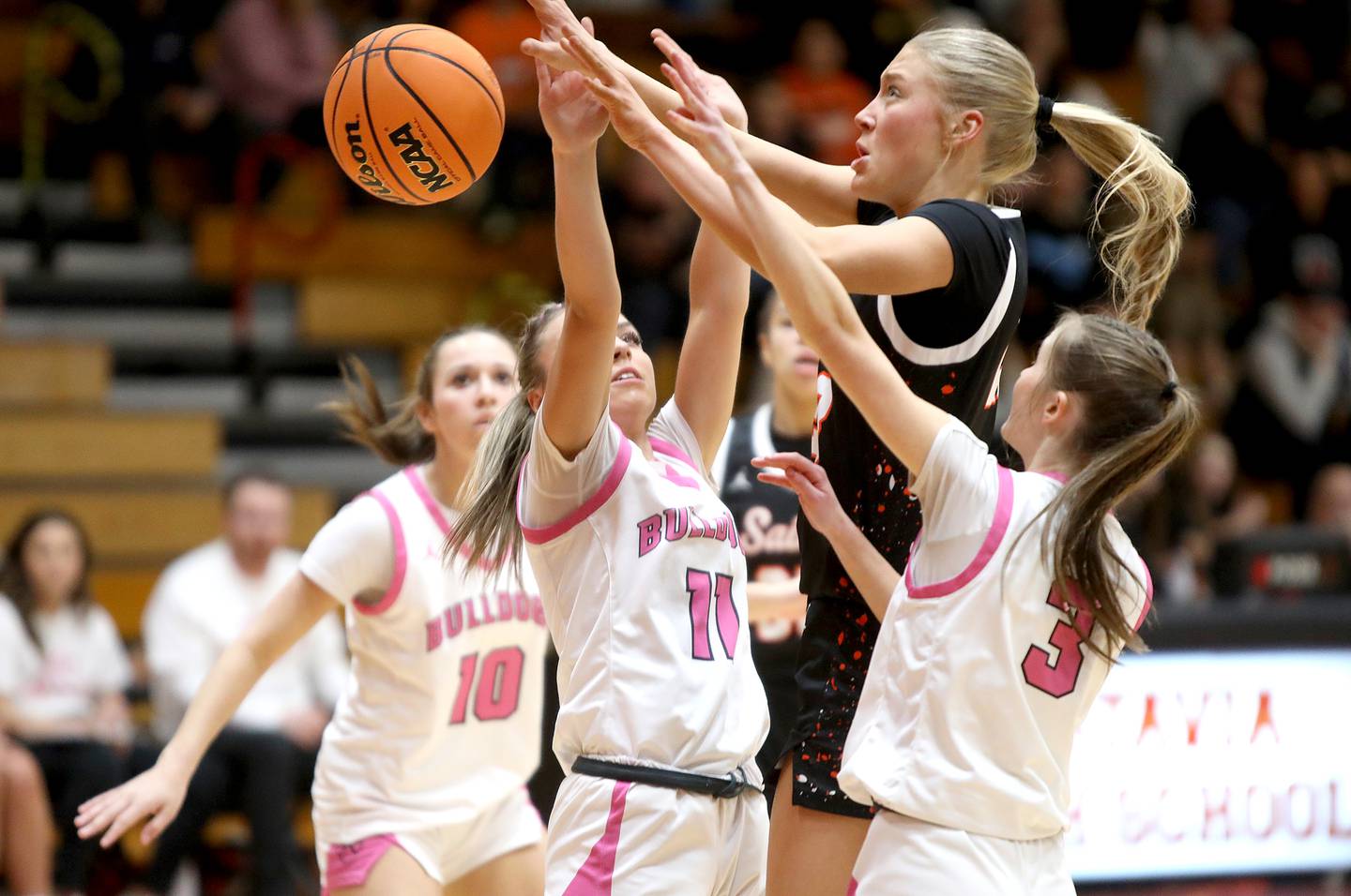 St. Charles East's Alyse Price (center) goes up for the rebound during a game against Batavia on Thursday, Feb. 6, 2025 in Batavia.