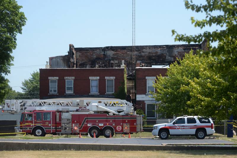 Two fire department vehicles were parked on Fourth Avenue on Monday, July 10, 2023, as fire department personnel installed a large Mutual Aid Box Alarm System (MABAS) tent in the Wipfli parking lot across from the charred apartment building at 406 E. Third St. in Sterling.