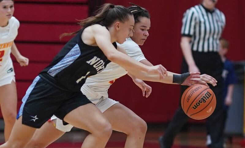 St. Charles North's Laney Stark (1) and Batavia’s Addie Prewitt (23) fight for a loose ball during a basketball game at Batavia High School on Tuesday, Dec 5, 2023.