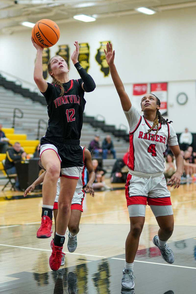 Yorkville's Elaine Gussman (12) drives to the basket against Bolingbrook's Sydney Dodd (4) during a Class 4A Metea Valley Regional final basketball game at Metea Valley High School in Aurora on Friday, Feb. 21, 2025.