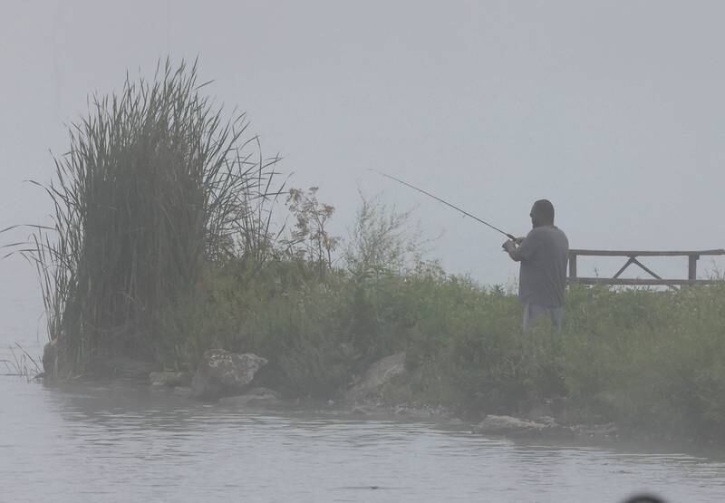 A fisherman tries his luck on a foggy morning Monday, July 22, 2024, in the lake Shabbona Lake State Recreation Area in Shabbona Township.