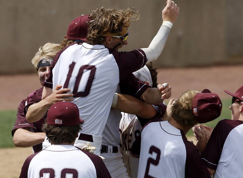Richmond-Burton’s Hayden Christianson, Connor Wallace and other players celebrate their win during a IHSA Class 2A supersectional baseball game against Timothy Christian at the Rockford Rivets Stadium in Rockford.