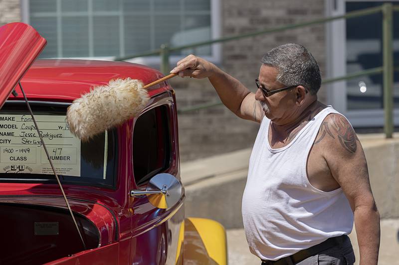 Jesse Rodriguez of Sterling dusts off his 1933 Ford Coupe Saturday, May 11, 2024 before judging begins at the Franklin Grove car show.