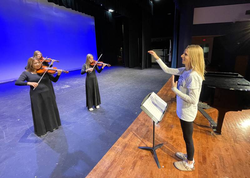 Lyndra Bastian, right, the orchestra director at Woodstock High School and Creekside Middle School, has been honored as a top teacher by School Band and Orchestra, or SBO+, magazine.