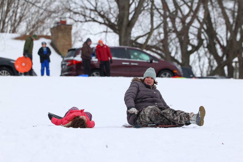 Hayley Villafuerte, right, reacts as her daughter, Viviana, 6, both of Grundy County, falls from her sled at Helgeson Park in Bradley on Sunday, Nov. 30, 2025.