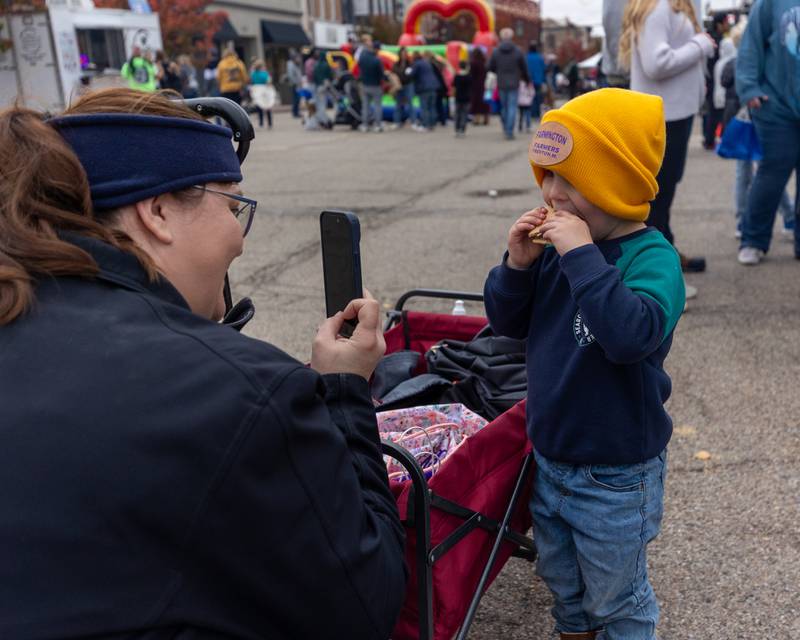 (from left) Amanda Miller takes photo of son Trenton eating a s'more at Frosty on First on Saturday, November 8, 2025 on First Street in La Salle.