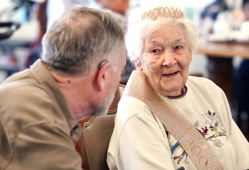 Heritage Woods of DeKalb resident Phyllis Fawcett, talks to her son Steve Haight, from Genoa, during her surprise 100th birthday party Thursday, March 21, 2024, at Heritage Woods.