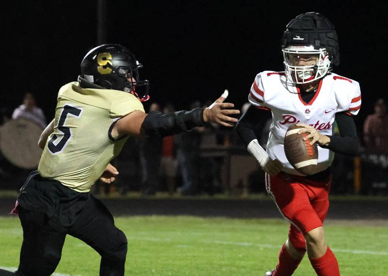 Ottawa’s Mark Munson avoids the pressure of Sycamore's Kyle Prebil during their game Friday, Sept. 27, 2024, at Sycamore High School.