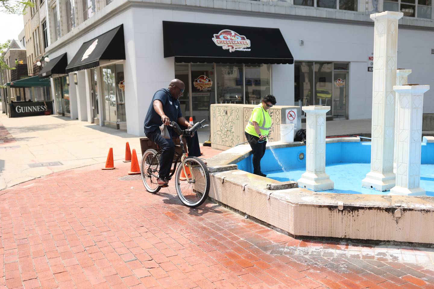 City worker Stanley Moore chats with Lily Nunez as she prepares the fountain for its opening within the next week along North Chicago Street in downtown Joliet. Tuesday, May 10, 2022, in Joliet.