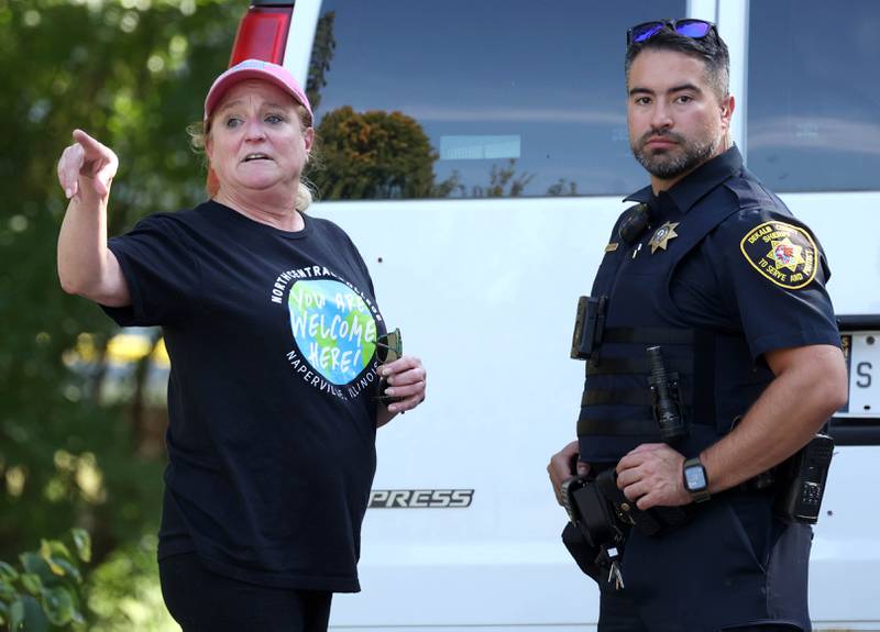 Molly Swick, a longtime friend of one of the victims talks to a DeKalb County sheriff’s deputy Tuesday, Sept. 30, 2025, in front of a house in the 1300 block of Oakland Drive in Sycamore where two people were found dead Tuesday morning.