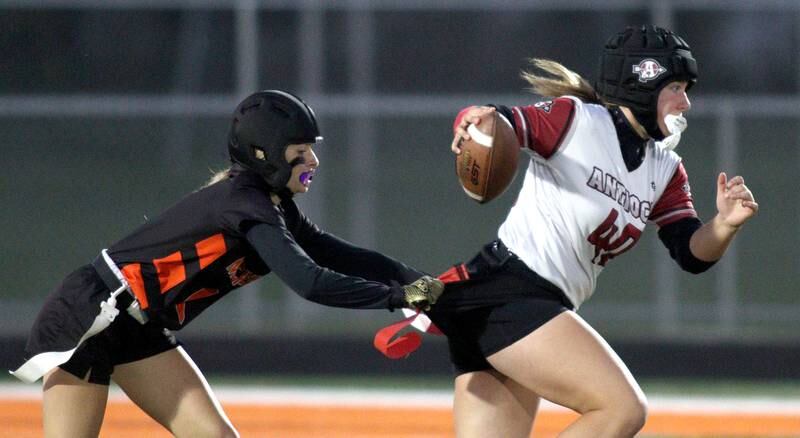 Antioch’s Tanner Ludwig, right, tries to escape McHenry’s Chloe Casey in IHSA Regional Title Game action flag football at McHenry High School in McHenry on Thursday, Oct. 10, 2024.