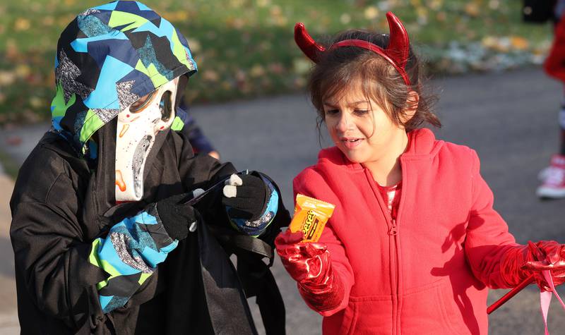 Damian Ortega, 7, and his sister April, 5, compare their candy as they trick-or-treat on Halloween Tuesday, Oct. 31, 2023, in DeKalb.