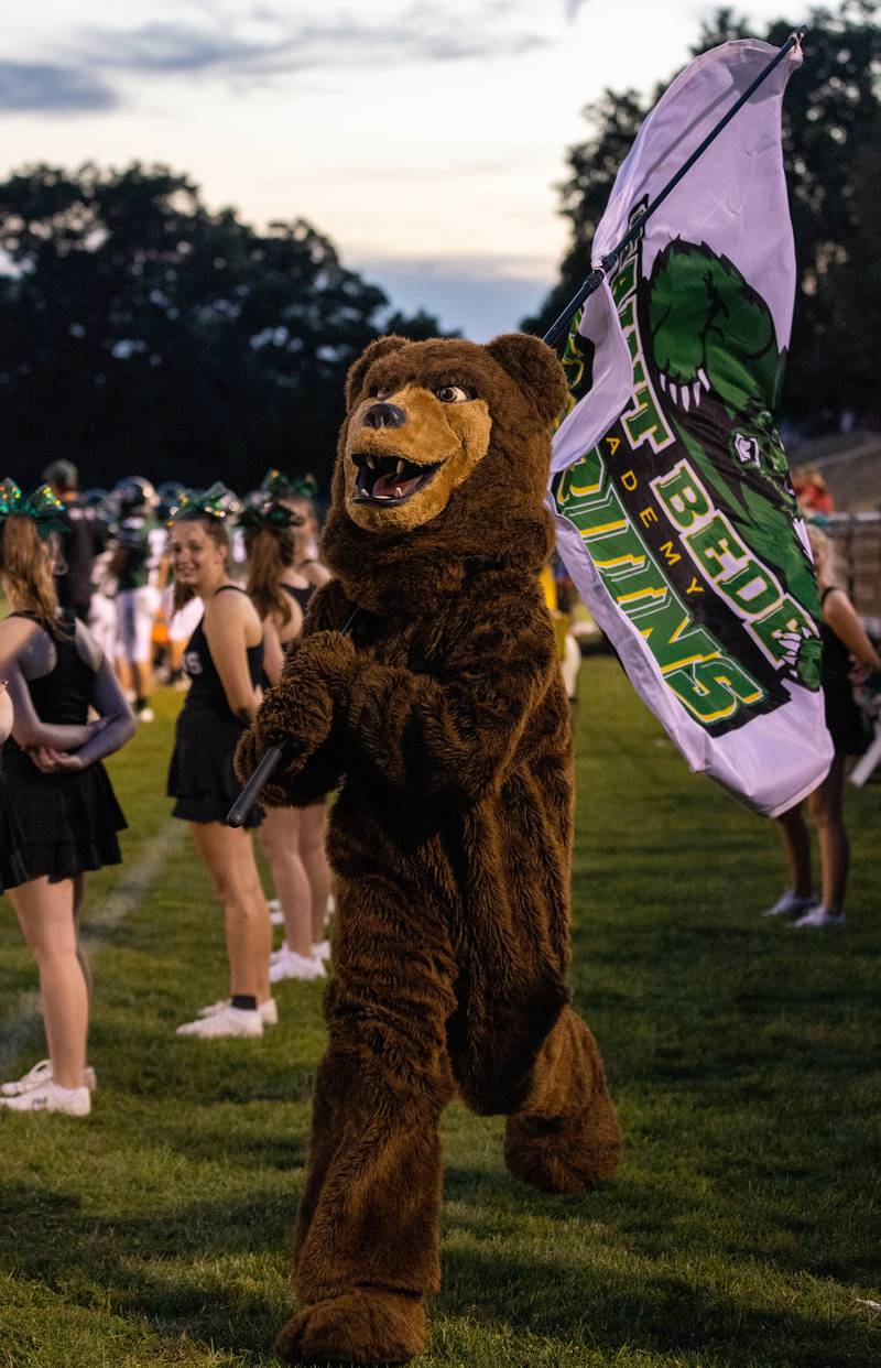 The St. Bede Bruin runs through the cheerleader formation on the sidelines Friday, Sept. 2, 2022 in Peru.