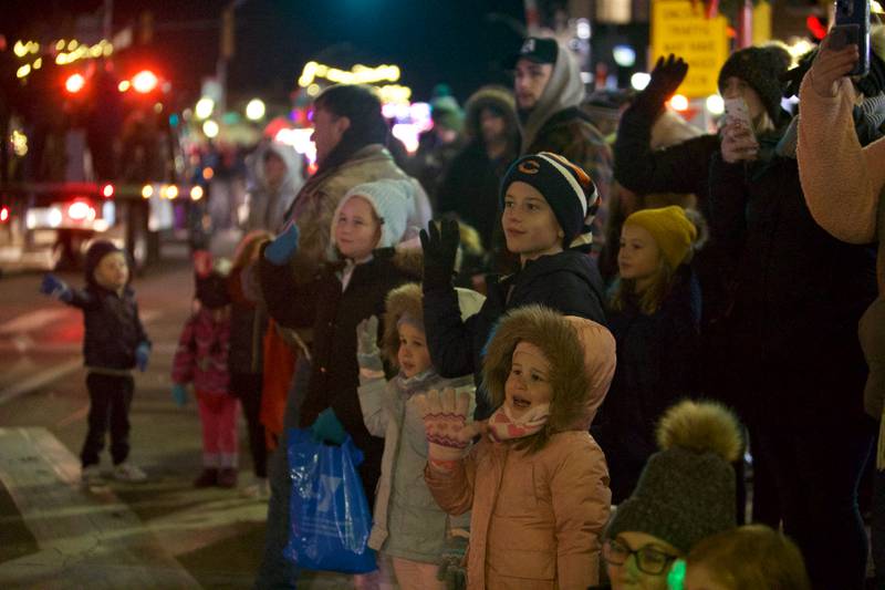 Parade goers wave as they see Santa coming in the Frosty & Friends Parade at the Holly Days Winter Festival on Saturday, Dec. 3,2022 in Westmont.