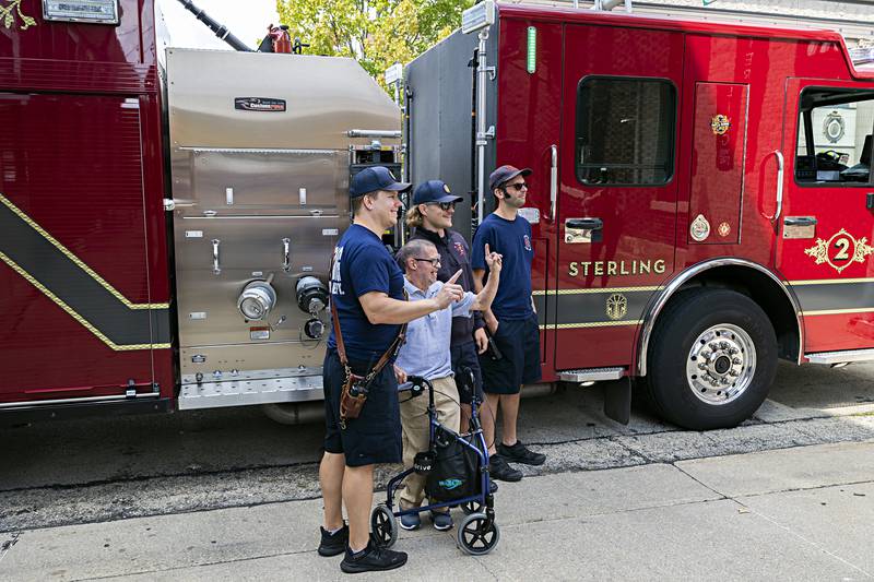 Firefighters Eric Behrens (left), Nick Hammer and Alex Vlakancic pose with Merlin after their ride Sunday, Sept. 17, 2023.