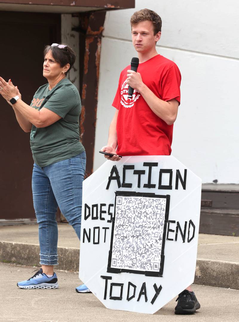 Northern Illinois University student Logan Sperling speaks as Mary Lynn Buckner, one of the organizers, applauds Saturday, June 11, 2022, during a March For Our Lives event at Hopkins Park in DeKalb. The March For Our Lives initiative advocates for, among other things, an end to gun violence, updated gun control legislation and policy targeting gun lobbyists.