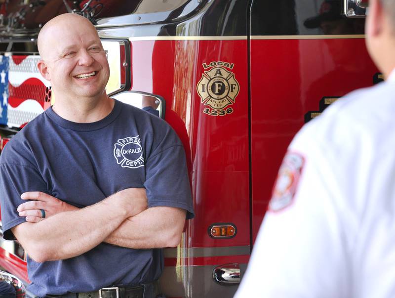 DeKalb firefighter Andrew Romano chats with coworkers in the apparatus bay Tuesday, May 16, 2023, at Fire Station 3 in DeKalb.