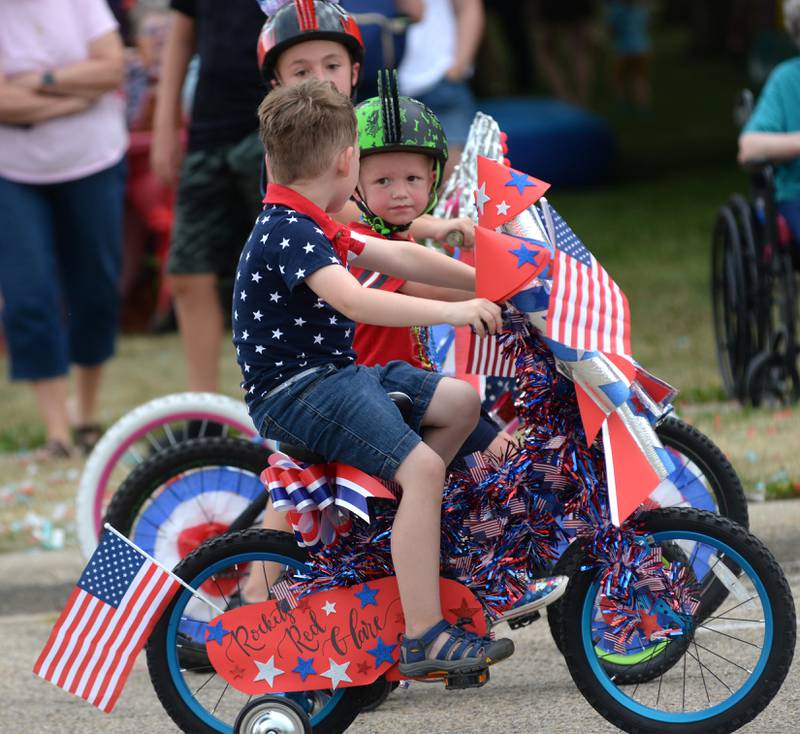 Three kids talk shop as they wait for the start of the Let Freedom Ring Kiddie Parade on Saturday, July 5, 2025.