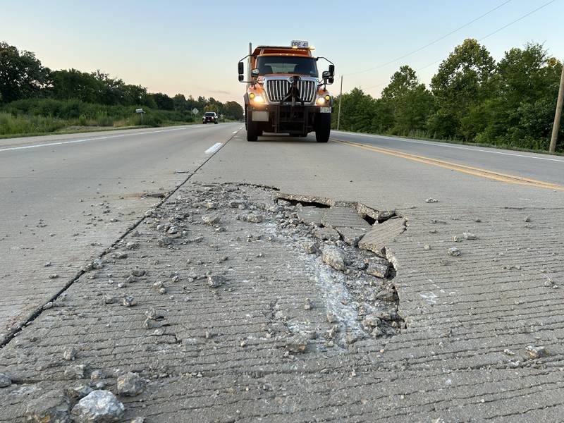 An Illinois Department of Transportation truck blocks motorists from driving over a pavement blowout Illinois Route 2 at Townline Road, south of Byron, on Tuesday evening, July 1, 2025. The state highway was closed between Oregon and Byron as crews patched the roadway. There was another blowout further south, north of Silver Ridge Golf Course.