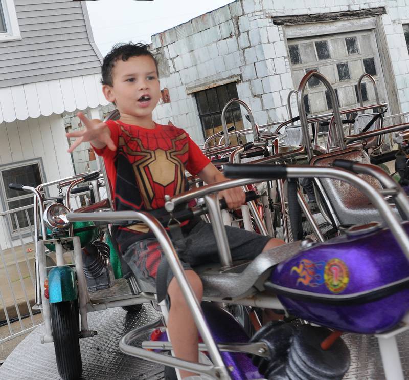 Jack Henry shows he can ride a motorcycle with only one hand while riding a carnival amusement Thursday, July 7, 2022, during the Marseilles Fun Days carnival.