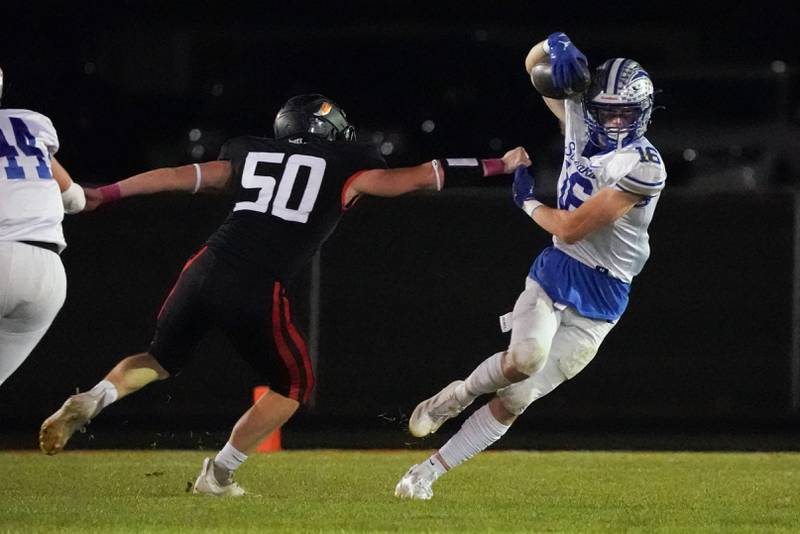 Woodstock's Charlie Walrod (16) returns a kick-off against Sandwich’s Peter Popp (50) during a football game at Sandwich High School on Friday, Oct. 11, 2024.