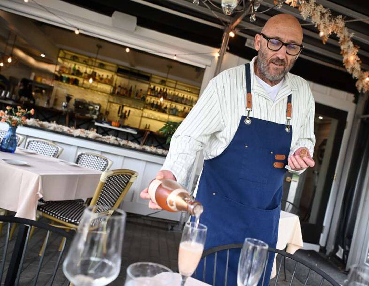 General manager Tom Dowd serves a sparkling wine at Mockingbird Bar + Garden in East Dundee.