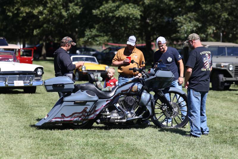 A group of veteran check out the patriotic themed bike at the 11th Annual Operation Firm Handshake Veteran’s Picnic on Saturday, Sept. 7, 2024 in Coal City.