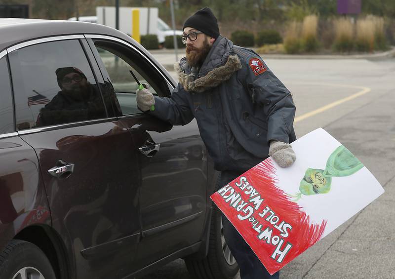 Mike Mueller, a Starbucks shift lead and a member of the union’s bargaining team, tries to convince a customer not to get a drink Thursday, Nov. 17, 2022, at the Cary location on Starbucks' Red Cup Day. Workers at Starbucks in Cary joined other workers across the country seeking to convince the company to better negotiate with its unionized locations.
