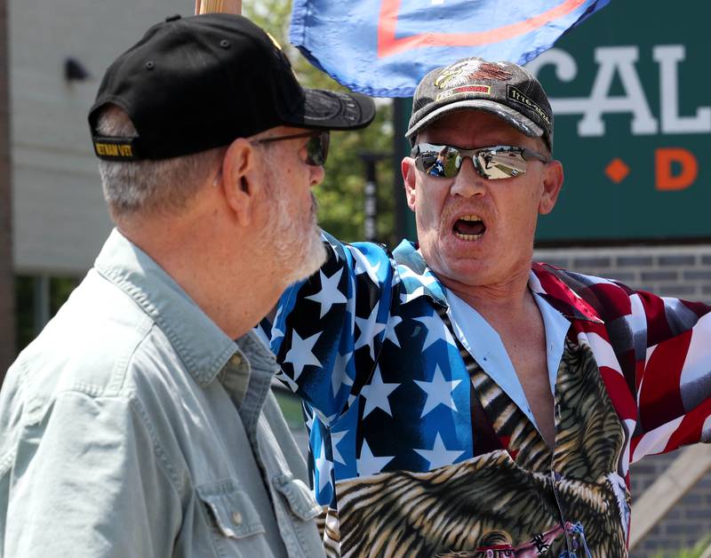 Steve Bellows, (right) from DeKalb, who is a supporter of President Donald Trump has a few words with a protester Saturday, June 14, 2025, during a No Kings rally along Sycamore Road at Hopkins Park in DeKalb. The group was protesting the policies of President Donald Trump and his administration.