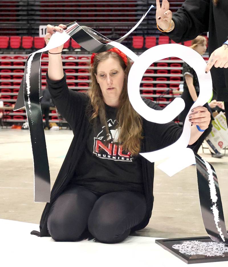 Jessica Labatte, Northern Illinois University associate professor of art, lays the template on the giant paper snowflake she is making with her photography students Tuesday, March 29, 2022, in the Convocation Center at NIU in DeKalb. The students are attempting to break the world record for the largest paper snowflake.