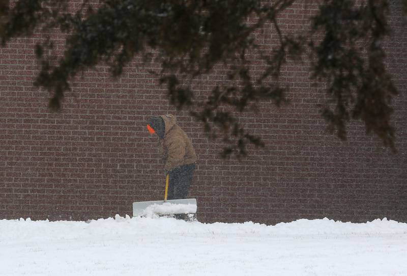 Snow is removed from a sidewalk at Richmond Grade School, 5815 Broadway Street, on Thursday, Feb. 16, 2023, in Richmond, after a winter storm moved through McHenry County creating hazardous driving conditions.