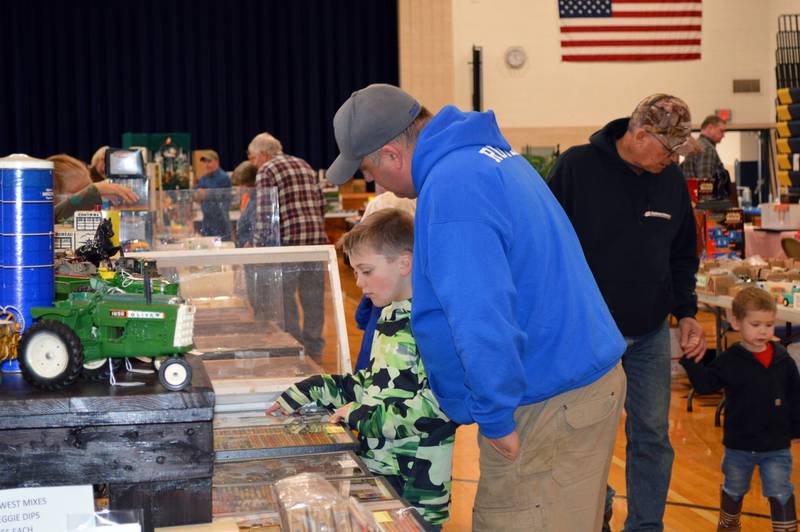 Kamdyn Ruter, 8, points out miniatures for sale at the Polo Lions Club’s 38th Farm Toy Show to dad Kyle Ruter, of Shannon. The event was held at Polo Community High School on March 4.