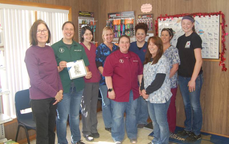 Serena Lawfer, DVM, Haylee Knutti, DVM, and Morrison Veterinary Clinic staff, Ginny K., Jacobi Winters, Brittany Milnes, Lisa Bush, Ashley Beyers, and Donna Rus receive a plaque from Barb Peterson, an Odell Public Library Friend.