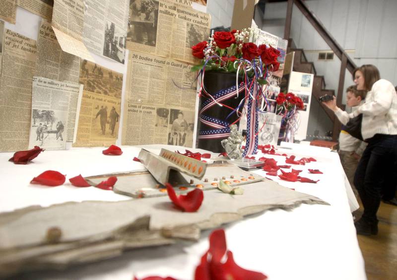 Julie Olczyk of Oswego films mementos and news clippings  as a remembrance was held Saturday at Wonder Lake Fire Protection District Station 2 on the 40th anniversary of a midair military jet explosion that happened over the small, rural area northeast of Woodstock. The plane exploded midair at 9:11 p.m., and its flaming pieces rained over a 2-mile area near Greenwood. On board were more than two-dozen members of the Air Force Reserve and Air National Guard. Twenty-seven people died.