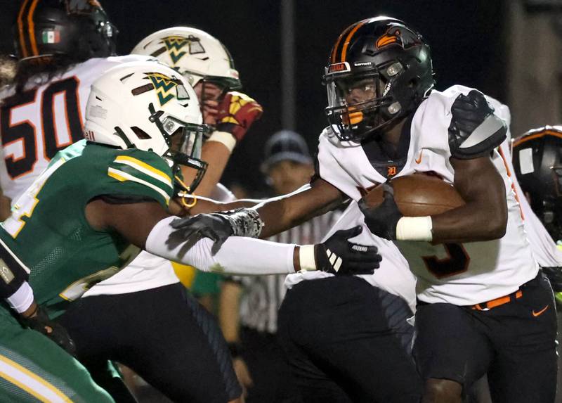 DeKalb's Mariyan Dudley tries shake the tackle attempt of Waubonsie Valley’s Ishmaiah Elliot during their game Friday, Oct. 11, 2024, at Waubonsie Valley High School in Aurora.