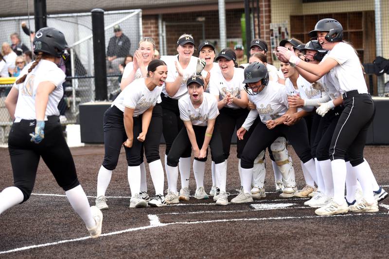 Members of the Bishop McNamara softball team greet Rhaya DePaolo, left, at home plate following her home run during the Class 2A Seneca Regional semifinals against Wilmington Tuesday, May 19, 2026.