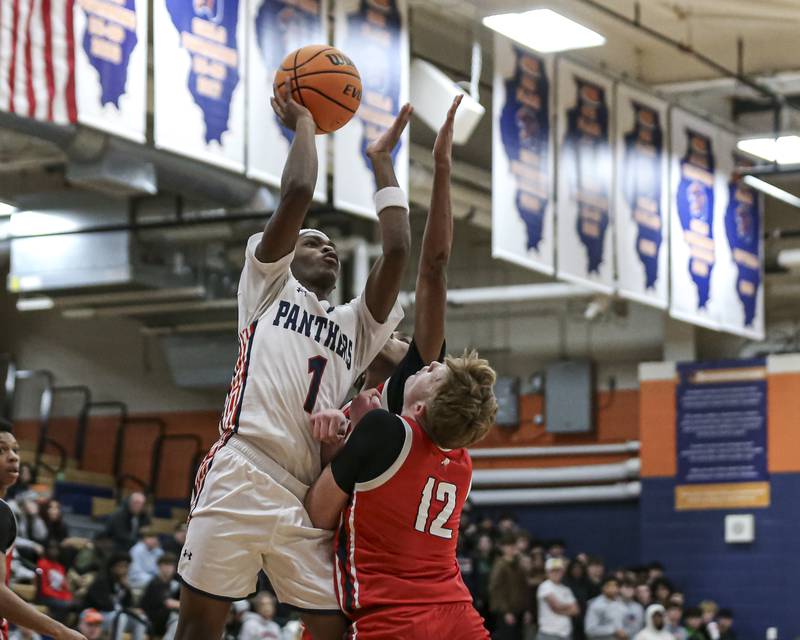 Oswego's TJ Wilson (1) puts up a shot over West Aurora's Drew Lundberg (12) during their basketball game between West Aurora at Oswego Monday, Nov 24, 2025 in Oswego.