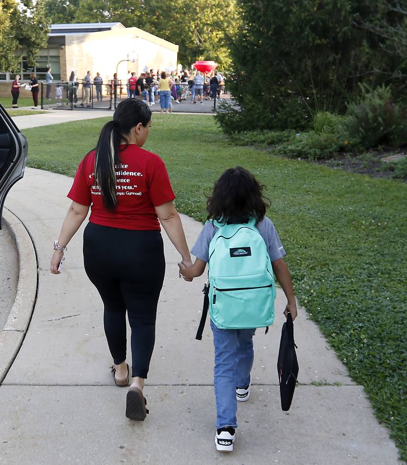 Sandy Carbajal walks her son, Bryan Cruz, 7, to Olson Elementary School on the first day of school  in Woodstock on Wednesday, Aug. 14, 2024.