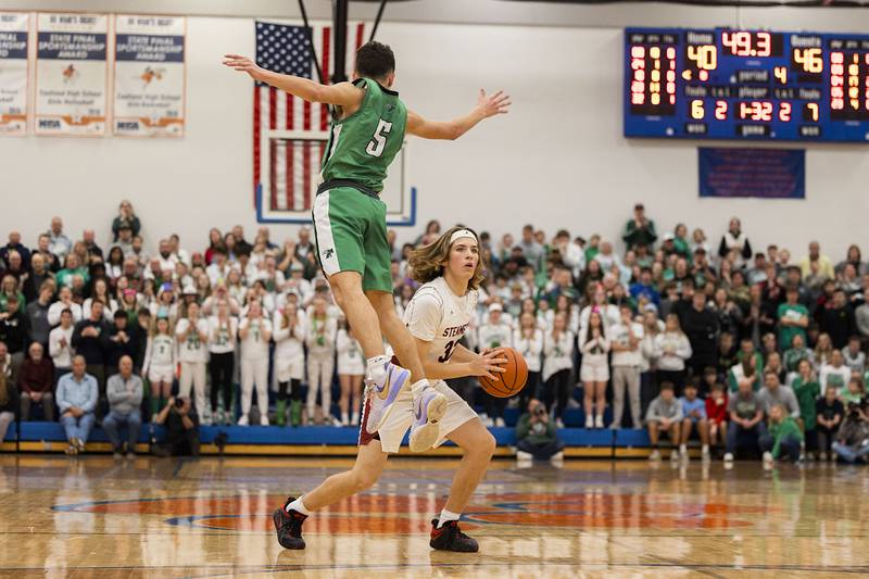 Fulton’s Reed Owen avoids a block by Scales Mound’s Charlie Wiegel before hitting a late three pointer Friday, March 3, 2023 in the 1A sectional final in Lanark.