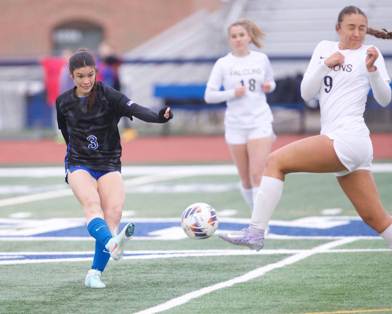 St. Charles North's Aubri Magana kicks the ball as Wheaton North's Talia Kaempf goes for the block on Thursday, April 10,2025 in St. Charles.