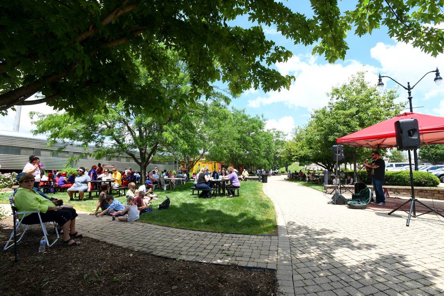 Dozens of attendees listen and eat lunch as Lupe Carroll performs for the crowd Wednesday during a 2021 Side of Jam event at the Harold & Jean Miner Festival Square in downtown Kankakee.