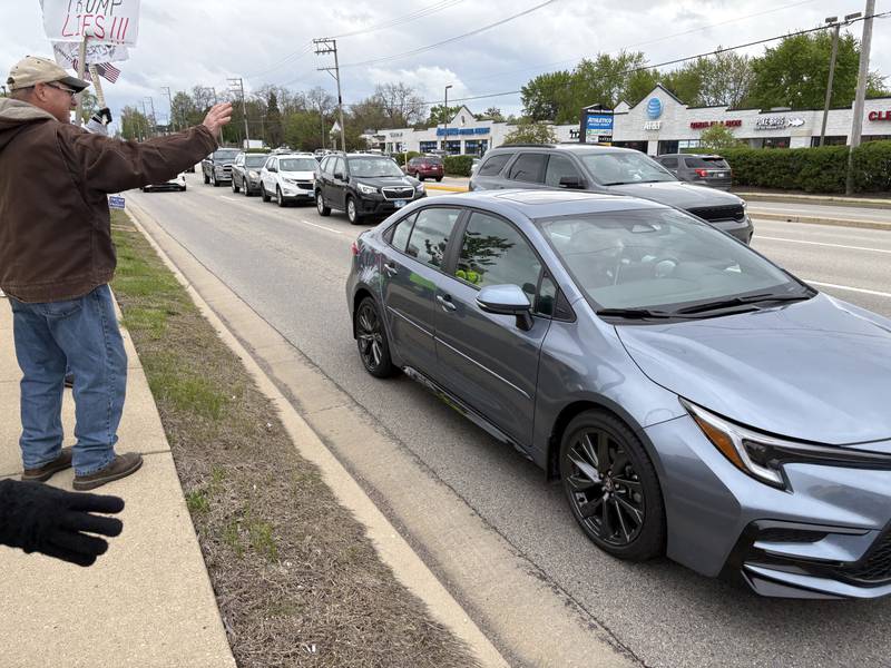 Protestors wave to a car during a May 1 protest in McHenry Friday May 1, 2026.