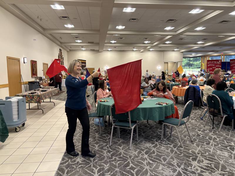Stephanie Diedrich waves a flag during the Magnificat prayer breakfast in Crystal Lake Oct. 11, 2025.