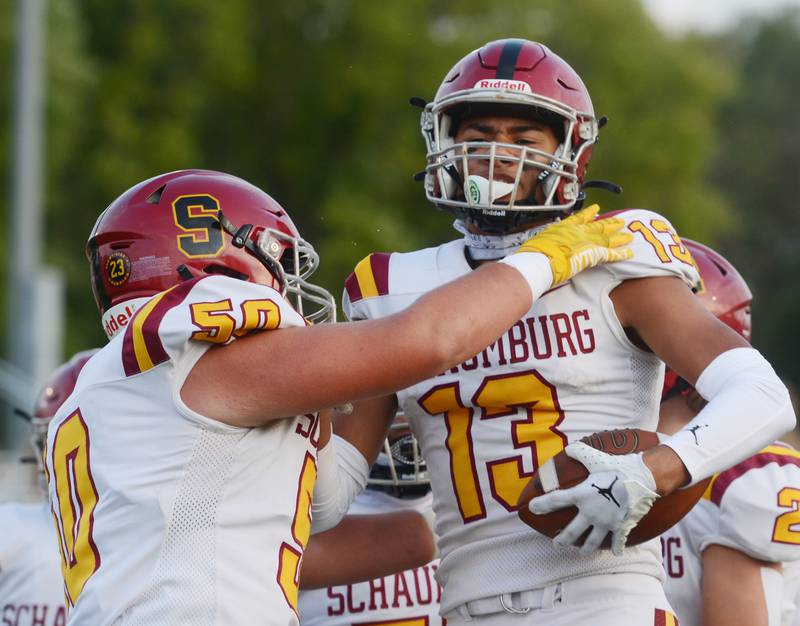 Joe Lewnard/jlewnard@dailyherald.com
Schaumburg’s Anthony Garcia, right, celebrates his first-quarter touchdown with teammates including Matthias Zubcek during Friday’s game at Maine West.